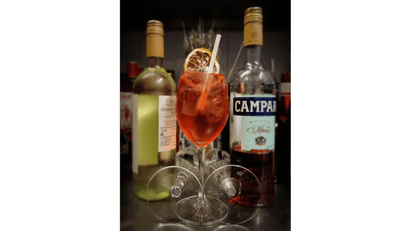 bicicletta cocktail image with campari and wine bottle in background