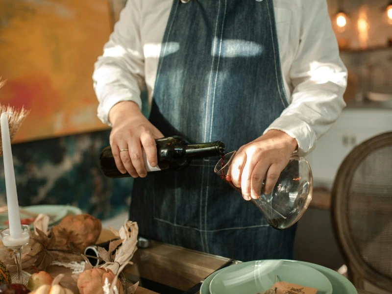 man pouring wine in a decanter