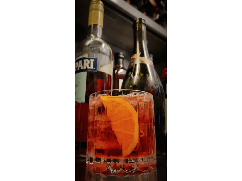 negroni sbagliato with prosecco and campari bottles in the background